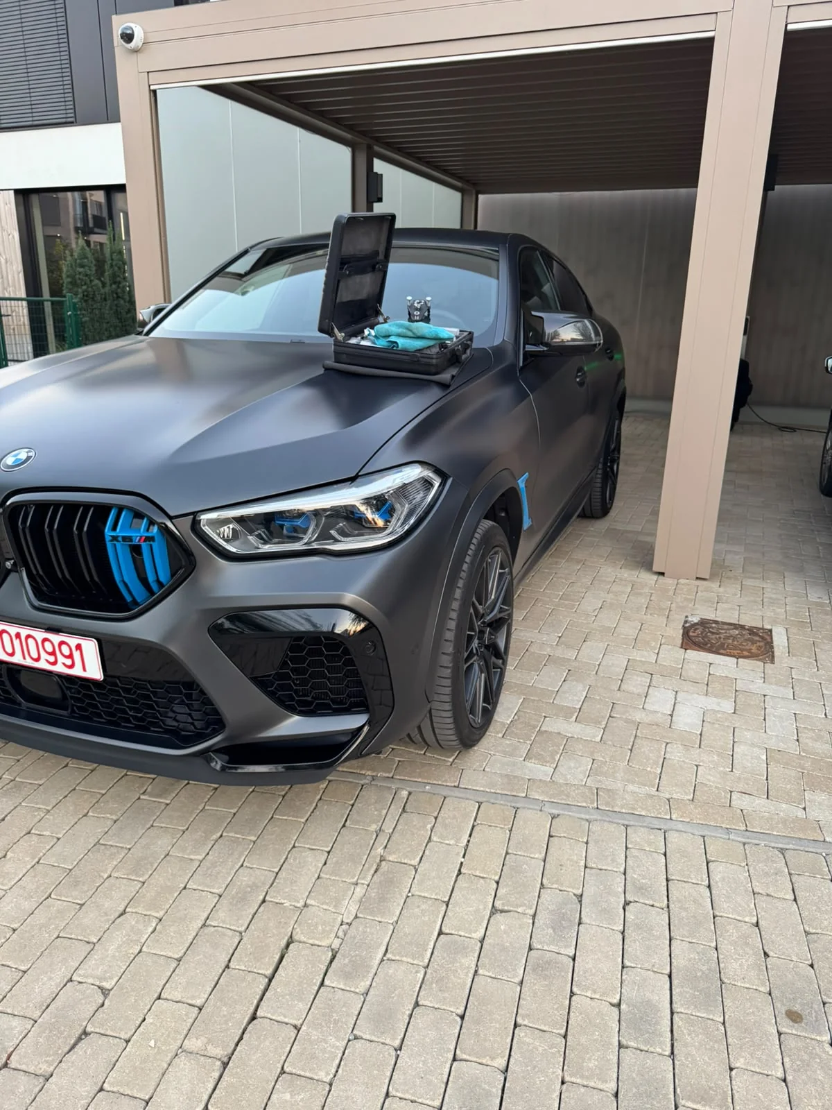 Vedere de ansamblu intervenție parbriz BMW X6 M Competition în carport
