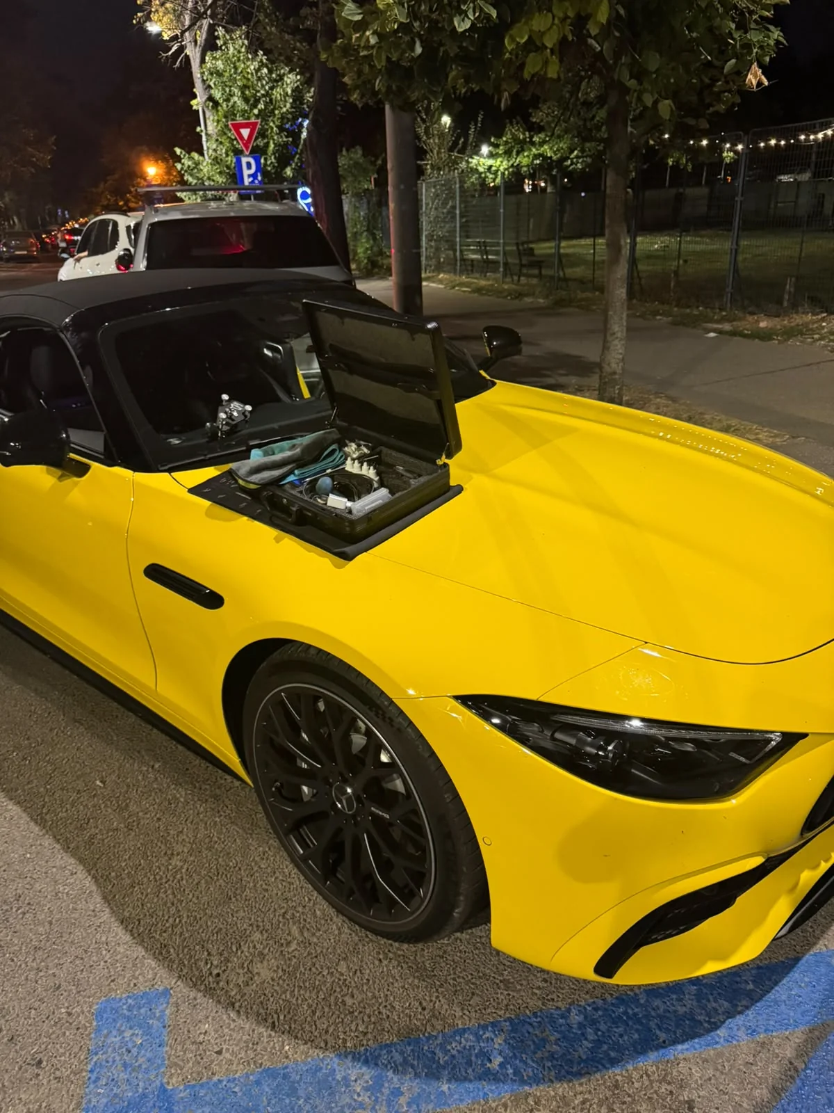 Perspectivă din profil Mercedes-AMG SL galben cu punte de reparat parbrize