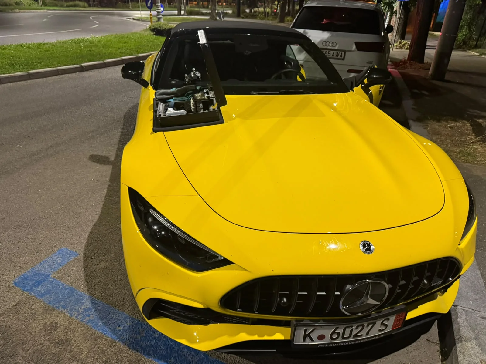 Cadru larg Mercedes AMG SL galben noaptea la reparație parbriz