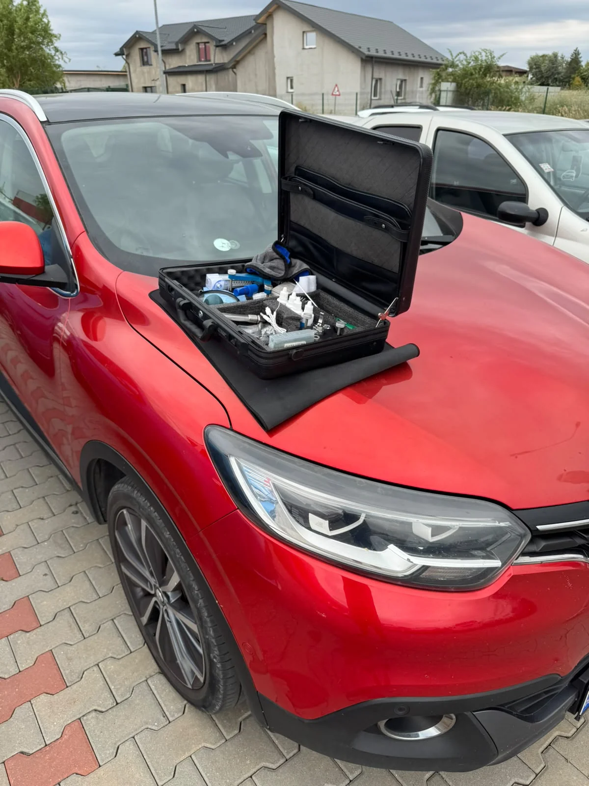 Renault Kadjar roșu cu trusa de reparație parbrize deschisă pe capotă